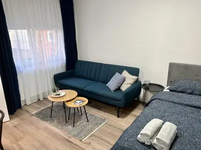 a living room with a couch and a bed at Apartman UMA in Bihać