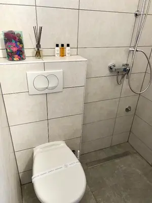 a bathroom with a white toilet and a shower at Apartman UMA in Bihać