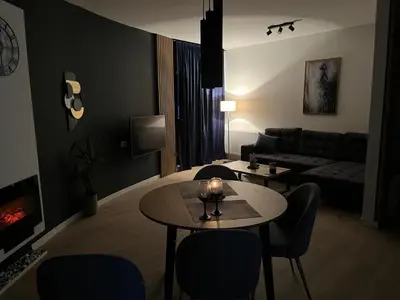 a living room with a table and chairs and a couch at Apartman Ena Fojnica in Fojnica
