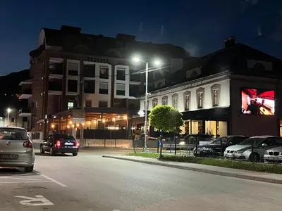 a street at night with cars parked in front of a building at Apartman Ena Fojnica in Fojnica