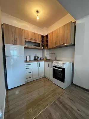 a kitchen with white appliances and wooden cabinets at Apartman Paradise Fojnica in Fojnica