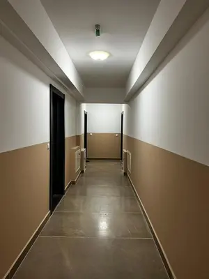 an empty hallway with doors and a tile floor at Apartman Paradise Fojnica in Fojnica