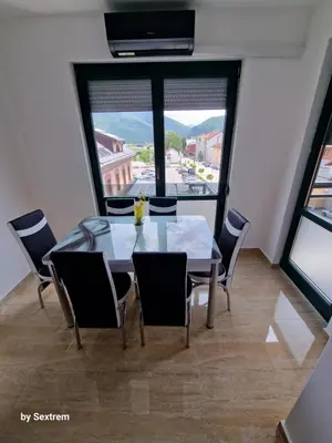 a dining room with a table and chairs and a large window at Apartman Paradise Fojnica in Fojnica