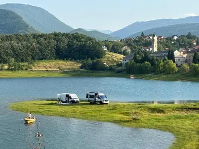 two rvs parked on the side of a lake at Auto Camping Grubeša in Dronjići