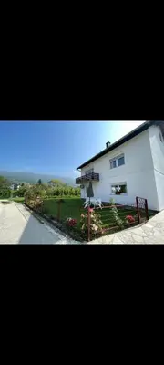 a white house with a fence next to a street at Villa Pliva Oasis in Jezero