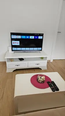 a living room with a television on a white entertainment center at Villa Park Banja Luka in Banja Luka