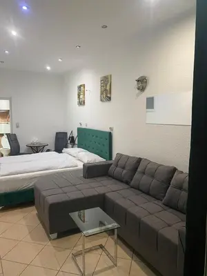 a living room with a couch and a bed at Mrkonjić Grad Apartmani in Mrkonjić Grad