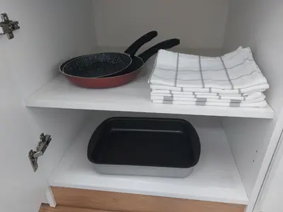 a kitchen shelf with a pan and a bowl on it at Apartman 