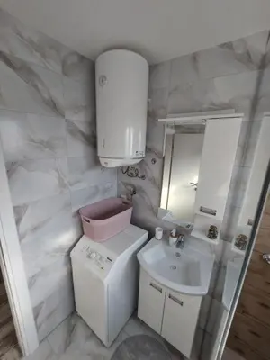 a small bathroom with a sink and a washing machine at Apartman 