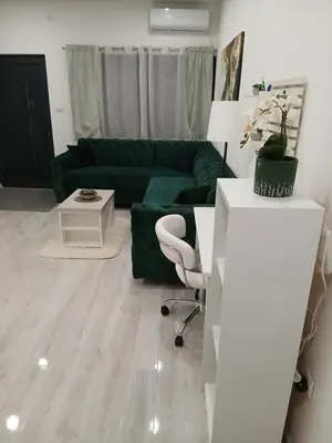 a living room with a green couch and a chair at Apartman DANA in Banja Luka