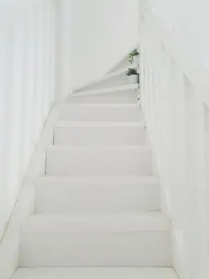 a white staircase with a plant on it at Apartman DANA in Banja Luka