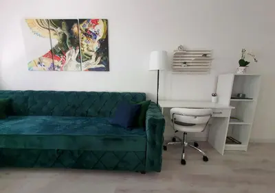 a living room with a green couch and a desk at Apartman DANA in Banja Luka