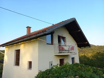a white house with a balcony on the side of it at Vikendica Savić in Šipovo