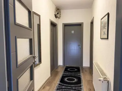 a hallway with a door and a rug on the floor at Apartman Kraljica 2 in Kupres