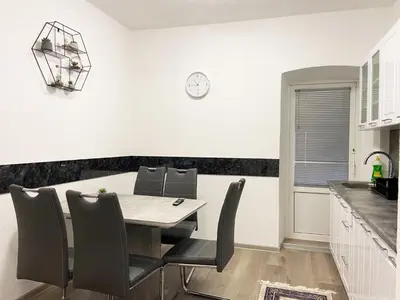 a kitchen and dining room with a table and chairs at Apartman Kraljica 2 in Kupres