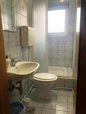 a bathroom with a white toilet and a sink at Apartman Kraljica 1 in Kupres