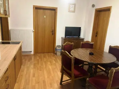a kitchen with a table and chairs and a television at Apartman Kraljica 1 in Kupres