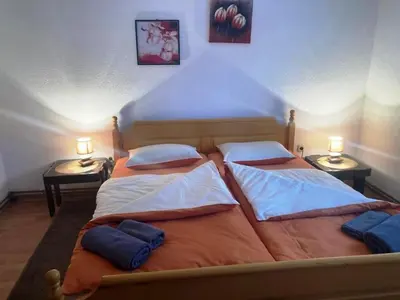 two beds in a bedroom with two lamps on tables at Apartman Kraljica 1 in Kupres