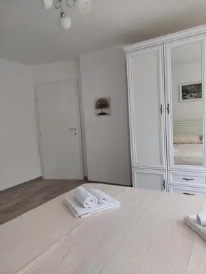 a bedroom with a white bed with towels on it at Apartman Cincar in Livno