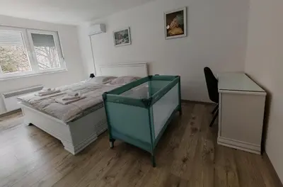 a bedroom with a bed and a table and a desk at Apartman Cincar in Livno
