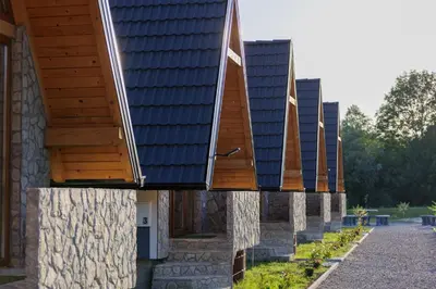 a row of houses with wooden roofs on them at Resort La Familia in Bihać