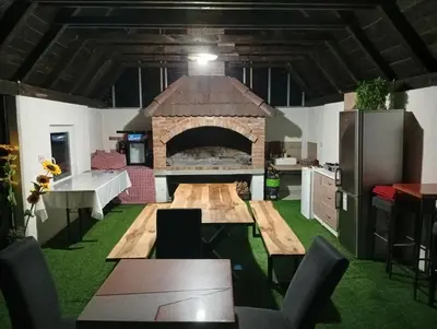 a kitchen with a large fireplace in the middle of a room at Resort La Familia in Bihać