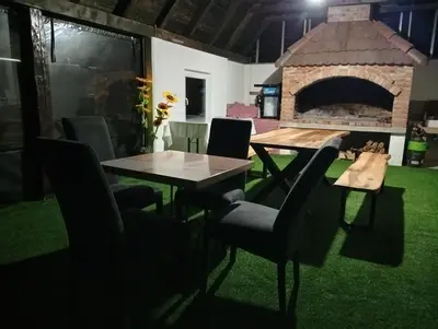a table and chairs in front of a brick oven at Resort La Familia in Bihać