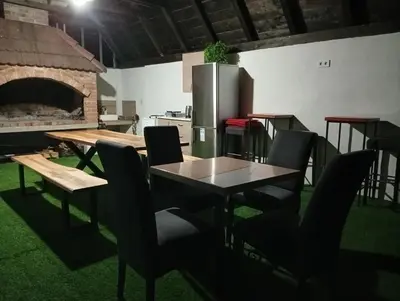 a kitchen with a table and chairs and a refrigerator at Resort La Familia in Bihać