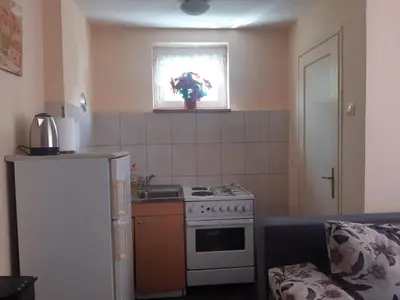a small kitchen with a stove and a window at Apartman LEON in Livno