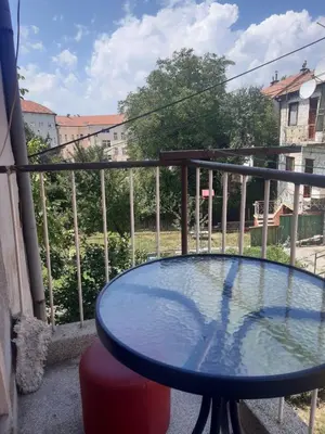 a balcony with a glass table on a balcony at Apartman LEON in Livno