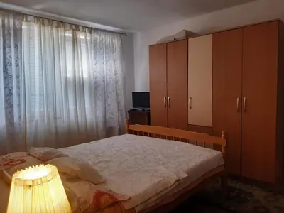 a bedroom with a bed and a cabinet and a lamp at Apartman LEON in Livno