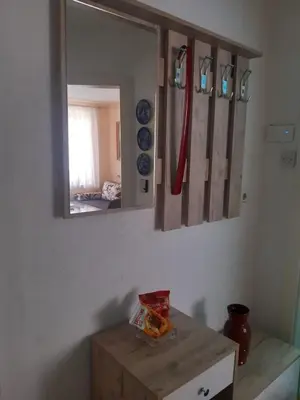 a mirror on a wall in a room with a table at Apartman LEON in Livno