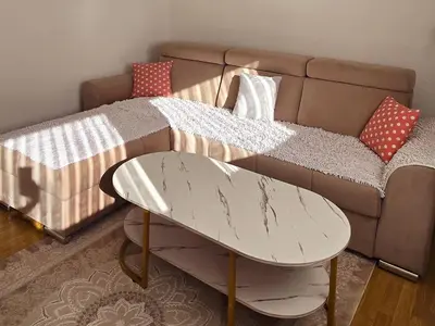 a couch with a table in front of a bed at Dina's house in Cazin