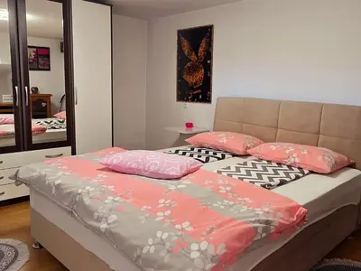 a bedroom with a bed with pillows and a mirror at Dina's house in Cazin