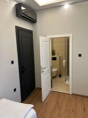 a bedroom with a door leading to a bathroom at Hotel Nacional in Bosanska Gradiška