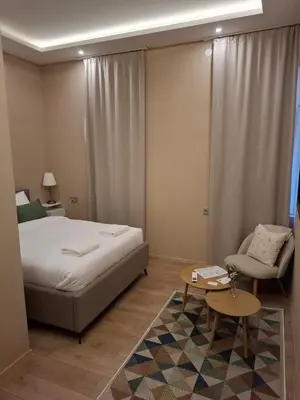 a bedroom with a bed and a chair and a table at Hotel Nacional in Bosanska Gradiška