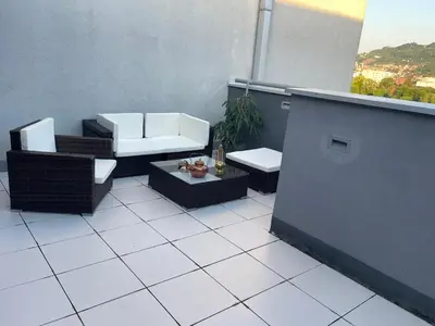 a balcony with chairs and a table and a window at Amsterdam in Banja Luka