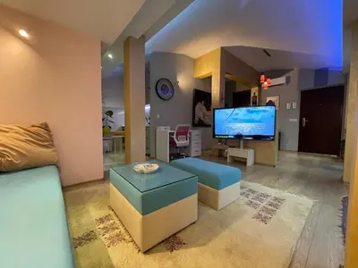 a living room with a couch and a large screen tv at Amsterdam in Banja Luka