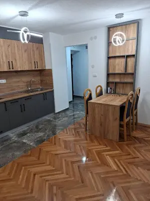 a kitchen and dining room with a wooden table and chairs at centar apartment in Banja Luka