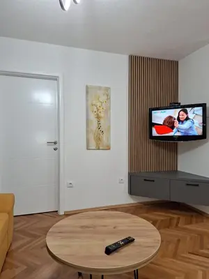 a living room with a tv and a table at centar apartment in Banja Luka