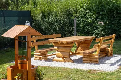a wooden picnic table and benches in a yard at VillaH Weekend House in Visoko