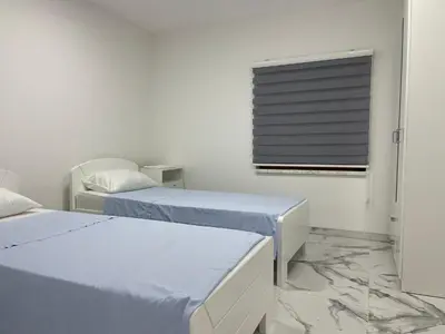 a white room with two beds and a window at Pišta-pause in Bihać