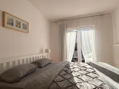 a bedroom with a bed and a large window at Moon Apartment Bihac in Bihać