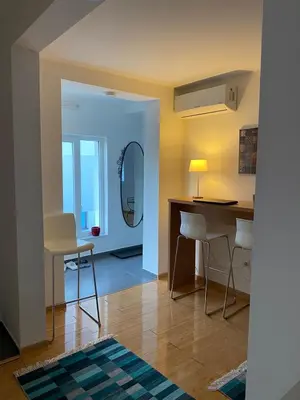 a living room with a table and chairs and a mirror at Moon Apartment Bihac in Bihać