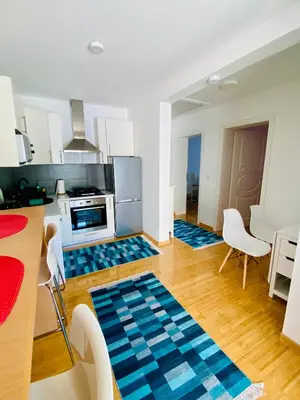 a kitchen with blue rugs in the middle of a room at Moon Apartment Bihac in Bihać