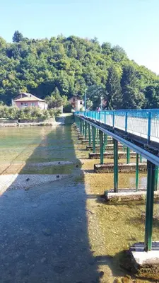 a blue bridge over a body of water at Apartman Mely in Kulen Vakuf