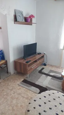 a living room with a television on a wooden table at Apartman Mely in Kulen Vakuf