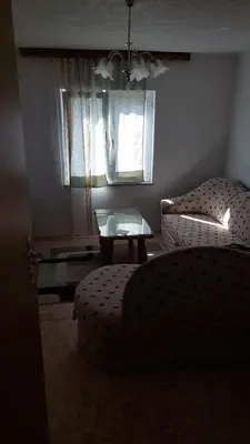 a living room with a couch and a table and a window at Apartman Mely in Kulen Vakuf