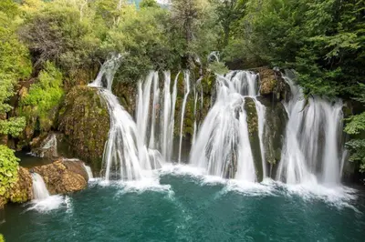 a group of waterfalls in a river with trees at Apartman Mely in Kulen Vakuf