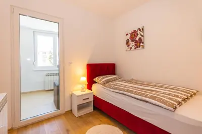 a small bedroom with a bed and a mirror at Apartman Krželj B2 in Livno